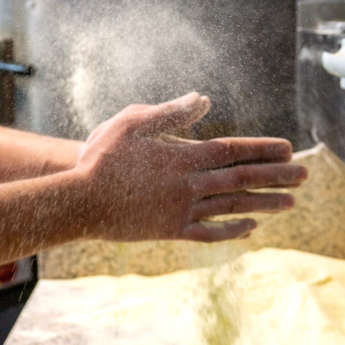 Unser Pizzaiolo klatscht die Hände, eine Wolke aus Mehlstaub fliegt über den Teig.